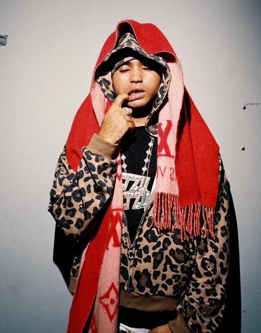 Suono Sai in a leopard-print jacket and red scarf